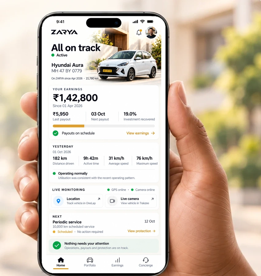 Hand holding a phone showing the ZARYA Owner App Home dashboard